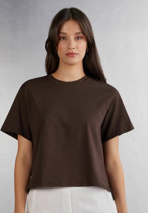 Brown cotton t-shirt with short sleeves, crew neckline, and a cropped design. Notable side slit details at the hem.