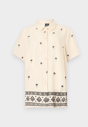 Κρεμ πουκάμισο με κοντά μανίκια και κουμπιά, με μαύρο σχέδιο φοίνικα και γεωμετρικό περιμετρικό μοτίβο στο τελείωμα.