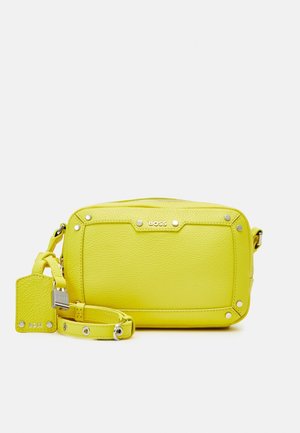 Sac bandoulière en cuir jaune vif avec clous argentés, logo BOSS, bandoulière amovible et étiquette en cuir assortie avec cadenas argenté.