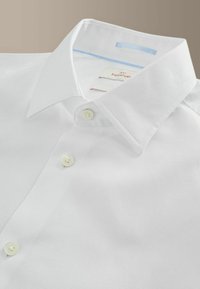 Bela srajca iz teksturirane tkanine, s klasičnim ovratnikom, prozornimi gumbi in subtilnim modrim poudarkom na notranjem delu ovratnika.