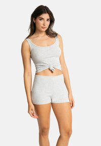 Débardeur en mélange de coton gris avec un détail avant noué, associé à un short gris assorti. Texture lisse et design ajusté.