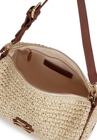 Torbka pleciona ze słomy z beżowym korpusem, brązowymi skórzanymi akcentami, złotymi elementami metalowymi, zamknięciem na zamek i materiałową podszewką z wewnętrzną kieszonką.