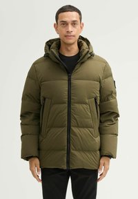 Oliwkowa ocieplana kurtka z zamkiem błyskawicznym, kapturem i dwoma bocznymi kieszeniami. Posiada pikowany wzór oraz czarne akcenty metalowe.