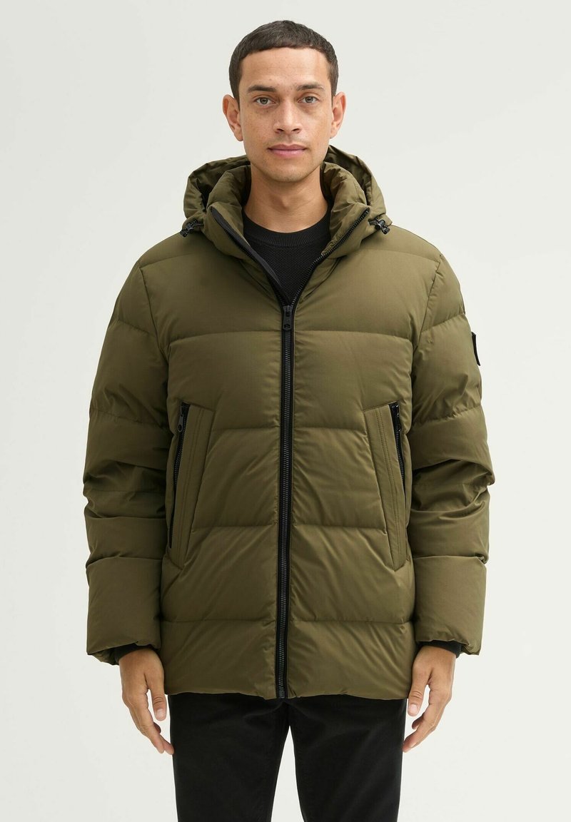 Oliwkowa ocieplana kurtka z zamkiem błyskawicznym, kapturem i dwoma bocznymi kieszeniami. Posiada pikowany wzór oraz czarne akcenty metalowe.