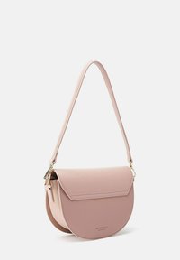 Roze leren crossbody tas met een ronde vorm, een gladde oppervlakte, klep sluiting en een dunne schouderband. Voorzien van gouden hardware accenten.