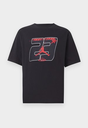 Μαύρο T-shirt με κοντό μανίκι με κόκκινο και λευκό γραφικό του αριθμού 23, ενός αστεριού και μιας κόκκινης σιλουέτας ενός παίκτη μπάσκετ που πηδάει.