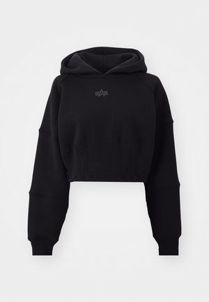 Zastrihnutá čierna mikina s kapucňou vyrobená z jemnej tkaniny, s rebrovaným pásom, nadrozmernými rukávmi a diskrétnym logom umiestneným v strede na hrudi.