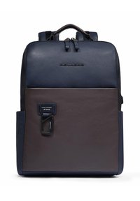 Mochila rectangular de cuero bicolor en azul marino y marrón con asa superior, cremallera frontal, correas para los hombros y mosquetón de metal adjunto.