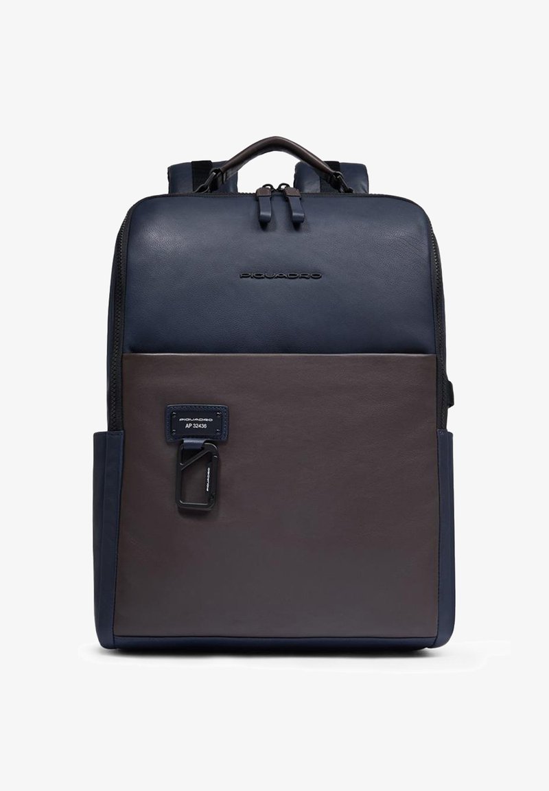 Mochila rectangular de cuero bicolor en azul marino y marrón con asa superior, cremallera frontal, correas para los hombros y mosquetón de metal adjunto.