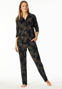 Black pajama set featuring a button-down shirt and pants, adorned with gold ginkgo leaf patterns. Made of soft, lightweight fabric.