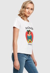 Balta trumpa rankovė t-šortas su grafika, kurioje Snieguolė laiko raudoną obuolį, o virš dizaino yra užrašas "Tik vienas kąsnis".