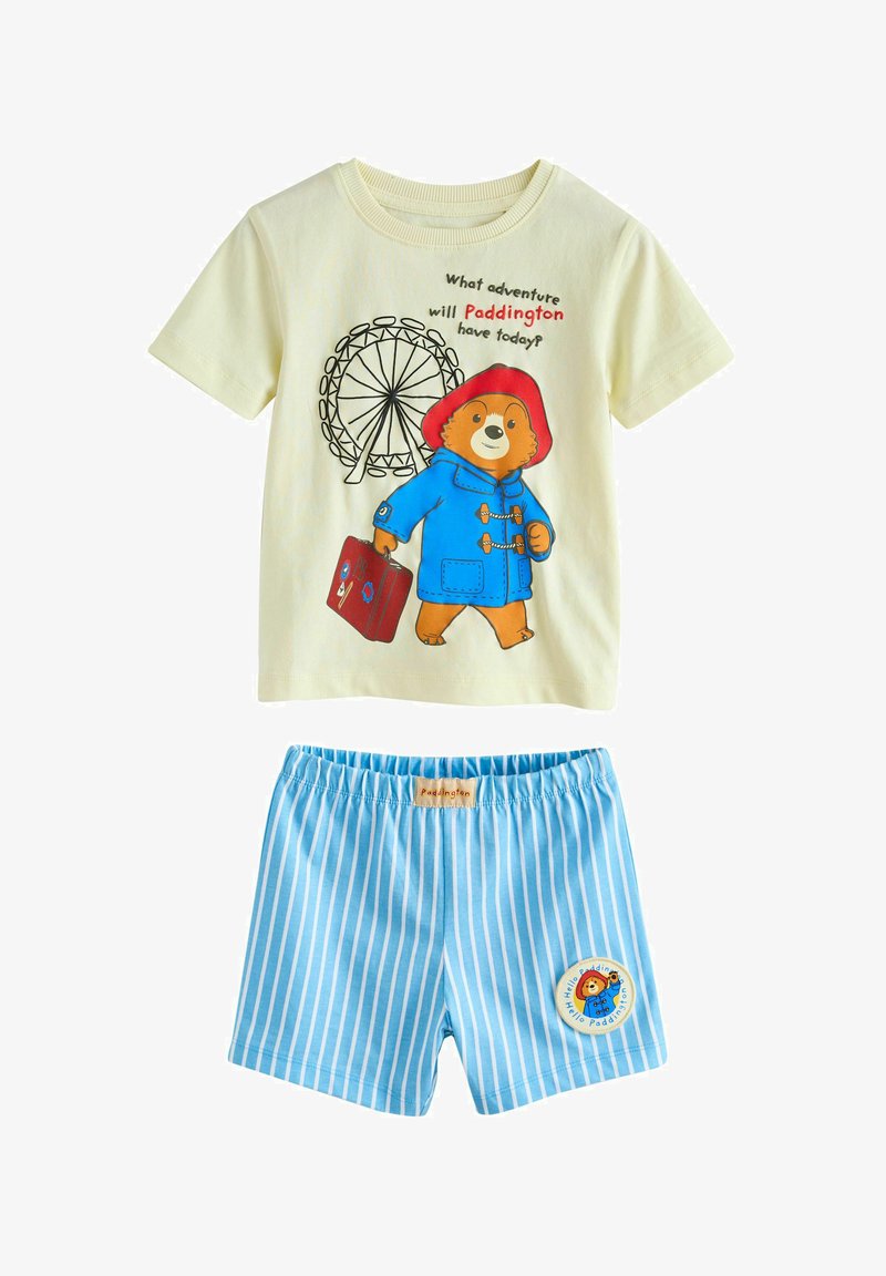 Zweiteiliger Kinderoutfit mit einem cremefarbenen Paddington-Bär T-Shirt und blauen gestreiften Shorts mit einem Paddington-Aufnäher.