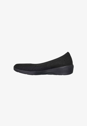 Scarpa nera senza lacci con tomaia in maglia e suola a zeppa bassa, progettata per il comfort e l'uso casual.