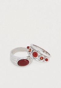 Ασημένια δαχτυλίδια με μεγάλο κόκκινο λίθο και πολλούς μικρότερους πολύχρωμους λίθους, με λεία επιφάνεια και στρωματοποιημένο σχέδιο.