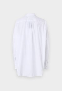 Camisa blanca de manga larga, tela ligera, dobladillo curvado, detalle de pliegue en la parte posterior, puños con botón, textura suave, diseño de cuello clásico.
