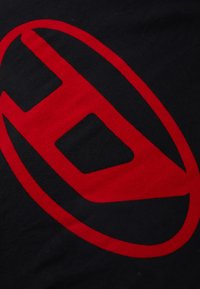 Tecido preto com um grande design gráfico vermelho que se assemelha a um óvalo que envolve uma forma angular, com um acabamento texturizado.