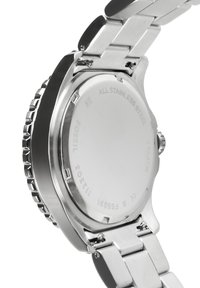 Montre en acier inoxydable avec un dos de boîtier poli, une couronne filetée et un bracelet en maillons métalliques. Les gravures incluent "TOUT EN ACIER INOXYDABLE" et "10 ATM."