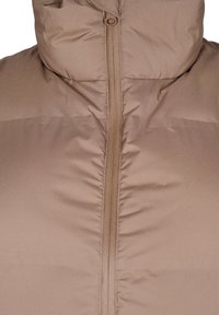 Giacca a vento marrone con colletto alto e zip full. Tessuto liscio con sezioni trapuntate, isolamento leggero e hardware minimale.