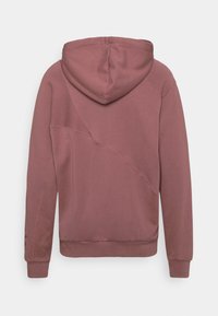 Hoodie i dämpad rosé, tillverkad av mjukt tyg. Har raglanärmar, en texturerad diagonalsöm och ribbade ärmslut och nederkant.