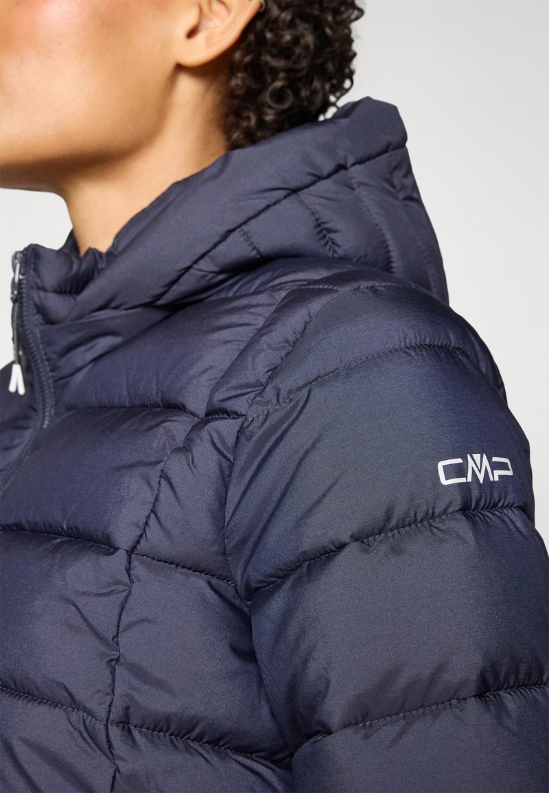 Giacca a vento imbottita blu navy con cappuccio, con sezioni trapuntate, zip frontale e logo CMP bianco sulla spalla sinistra. Tessuto testurizzato.