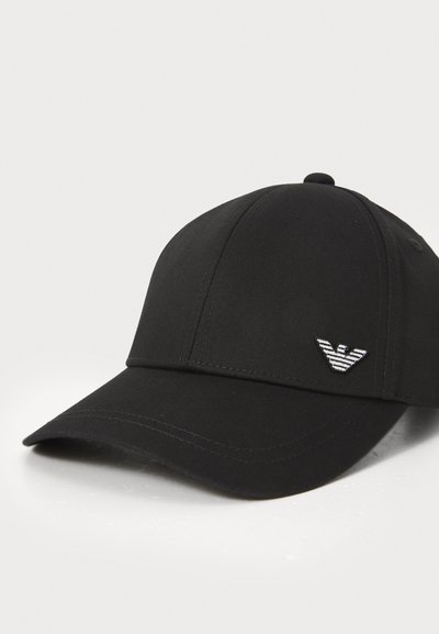 Casquette de baseball noire en tissu texturé, avec une visière courbée. Elle présente un logo brodé blanc sur le côté avant gauche.