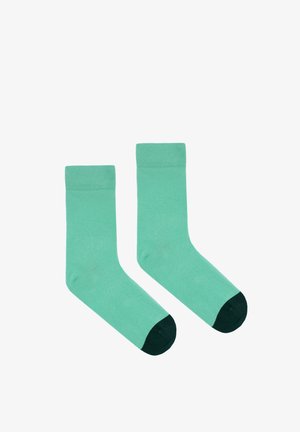 Bawełniane skarpetki w jednolitym kolorze miętowym z ciemnozielonym wzmocnionym palcem. Żebrowana mankiet na górze, standardowy krój długości crew.