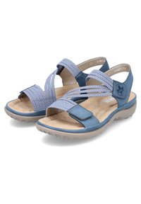 Blaue Sandalen mit überkreuzten Stoffriemen und einer soliden Lederbasis. Gepolsterte Sohle und hellgraue Gummisohle. Verstellbarer Riemenverschluss.