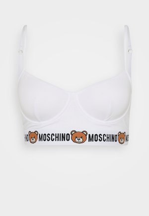 Biały stanik braletka o gładkiej fakturze, z grafiką rysunkowego misia i napisem "Moschino" na elastycznej taśmie u dołu.