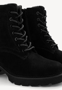 Black suede ankle boots with laces and a side zipper. Features textured surface, sturdy rubber sole, and contrast stitching details.