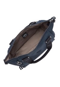 Marineblå shoppingtaske lavet af slidstærkt stof, med en lynlåslukning i toppen, brun inderforing og to korte håndtag. Bemærkelsesværdig charme detalje inkluderet.