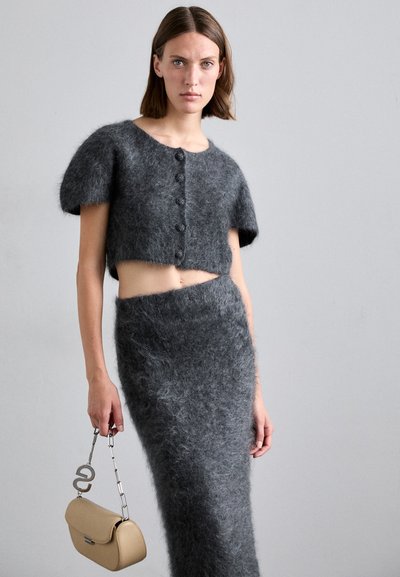 Korte, grijze mohair crop top met korte pofmouwen, gecombineerd met een bijpassende hoogderekrok, gedragen met een beige tas met een kettinghandgreep.
