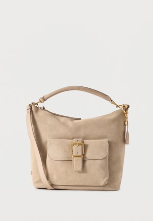Sac à main en suède beige avec une poignée supérieure, une bandoulière amovible et une poche avant dotée d'une fermeture à boucle dorée.