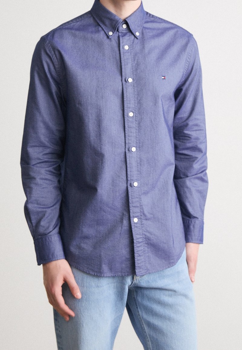 Camicia button-up blu navy, in cotone, maniche lunghe e colletto button-down. Presenta un piccolo logo sul petto e bottoni bianchi.
