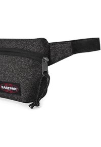 Borsa nera realizzata in tessuto testurizzato, con cerniera superiore con linguetta e tracolla regolabile. Presenta un patch con il logo Eastpak sulla parte anteriore.