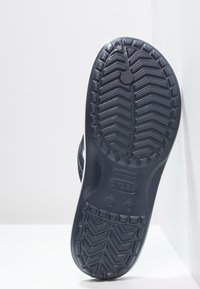 Must musta jalanõu tallal on tekstuuriga musta kummist pinnakujundus. Säält leidub ringikujuline logo ja suuruse märgised.