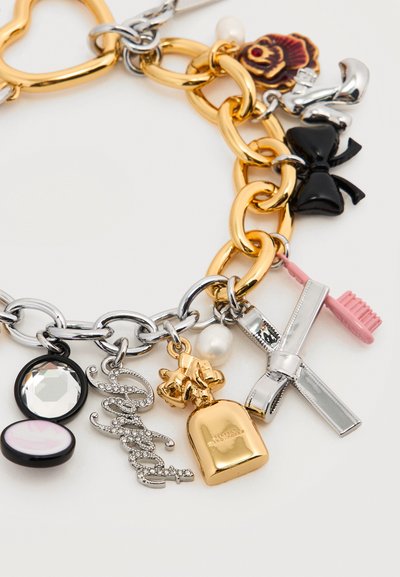 Βραχιόλι αλυσίδα από χρυσό και ασήμι με γούρια, όπως ένα μαύρο φιόγκο, ροζ οδοντόβουρτσα, χρυσό μπουκάλι αρώματος, λουλούδι, μαργαριτάρι και διακοσμητικά με κρυστάλλινες πέτρες που σχηματίζουν τη λέξη "Sweet".