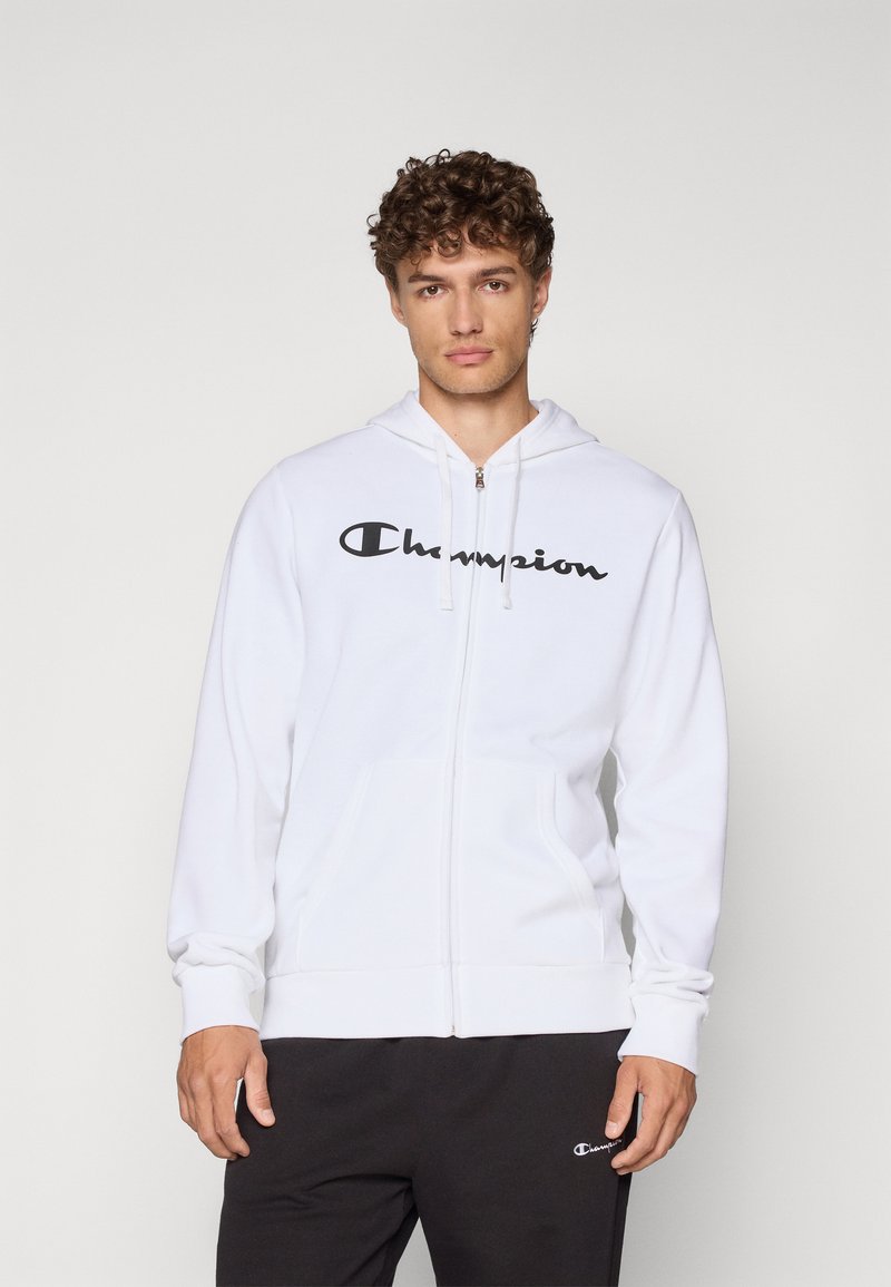 Hvit zip-up hettegenser laget av bomullsblanding, med en stor svart "Champion" logo på brystet, med snorhette og frontlommer.