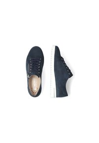 Baskets en suede marine avec semelles en caoutchouc blanches, bout rond et design à lacets. La chaussure gauche possède un détail de zip sur le côté. Légères et minimalistes.