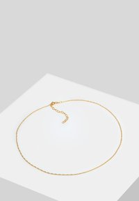 Guld kæde med et fint led-design og en lille justerbar spænde bagpå. Glat overflade og subtil glans.