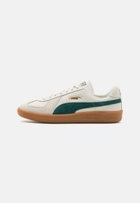Sneaker bianco con pannello in suede teal, design leggero, suola in gomma e accenti in logo dorato. Presenta una chiusura classica con lacci e un colletto imbottito.