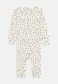 Hosszú ujjú csecsemő kezeslábas krém színben fekete pöttyökkel. Jellemzője a talpas lábak és a szoros mandzsetták a csuklóknál és a bokáknál. Puha pamut anyag.