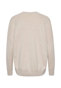 Pull en tricot beige avec épaules tombantes, manches longues, col rond large et ourlet en côtes. Tissu doux et texturé avec une apparence légère.