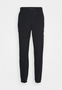 Pantaloni della tuta neri realizzati in materiale morbido; presentano una vita elastica con cordino e polsini affusolati. Inclusi dettagli con logo laterale.