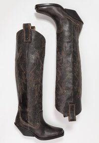 Botas de cuero negro hasta la rodilla con un acabado texturizado, que presentan bordados en forma de rayo marrón, puntera afilada y un tacón de cuña bajo.