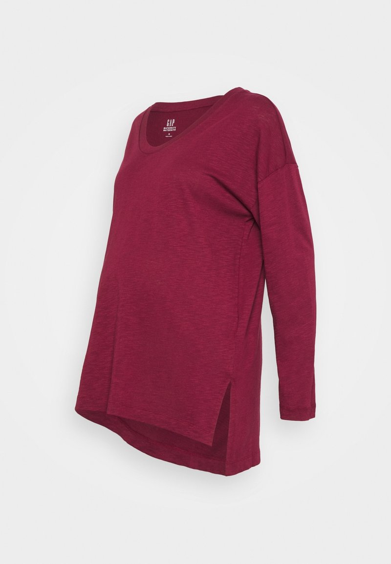 Bordový dlouhý rukáv s výstřihem do V a bočními rozparky. Vyrobeno z měkké, texturované tkaniny s volným střihem. Štítek viditelný na límci.