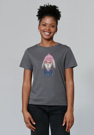 T-shirt grise avec un design de lapin portant des lunettes roses et un bonnet tricoté assorti, imprimée sur un tissu doux avec des manches courtes.