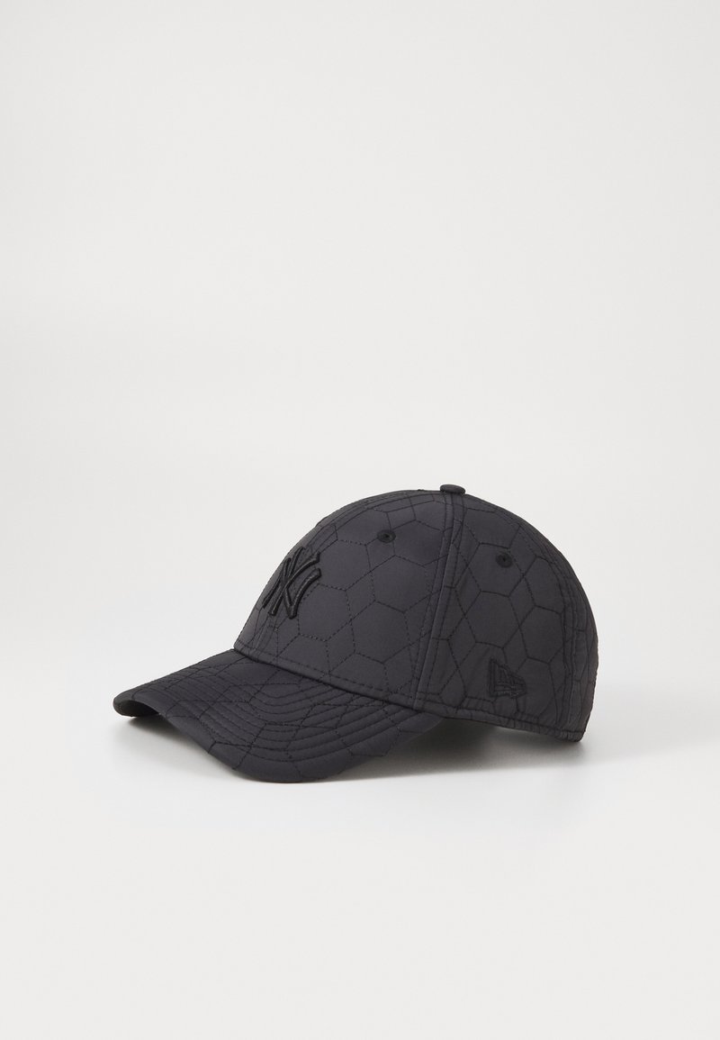Black cap with hexagonal quilted texture, featuring embroidered logo on the front and a curved brim. Constructed from a durable fabric.