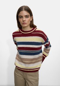 Maglione in lana con ampie strisce orizzontali in rosso, giallo, blu e beige, dotato di scollatura rotonda e vestibilità rilassata.