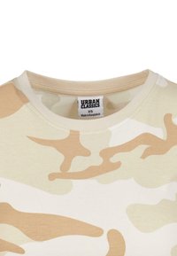 Kamuflasje T-skjorte i beige toner, med rund hals, myk stoff og lysebrune abstrakte mønstre. Merket synlig inni.