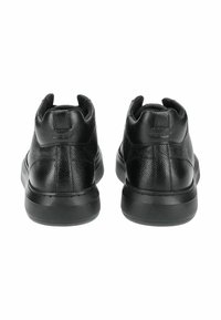 Černé kožené tenisky s texturovaným povrchem, polstrovaným límcem a černou gumovou podrážkou se vzorovaným gripem. Zadní pohled ukazuje minimální branding.